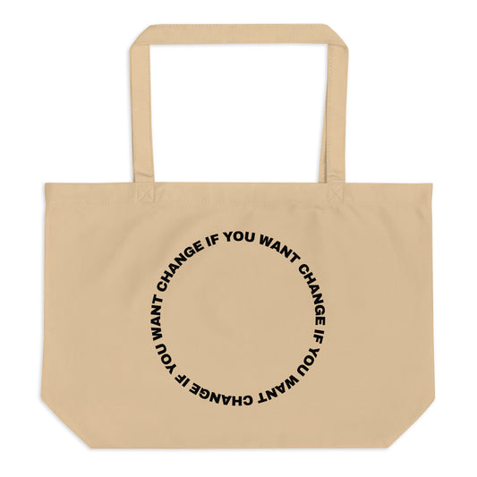 Black text in loop: "change if you want change" wrapped in a circle on an organic cotton tote bag