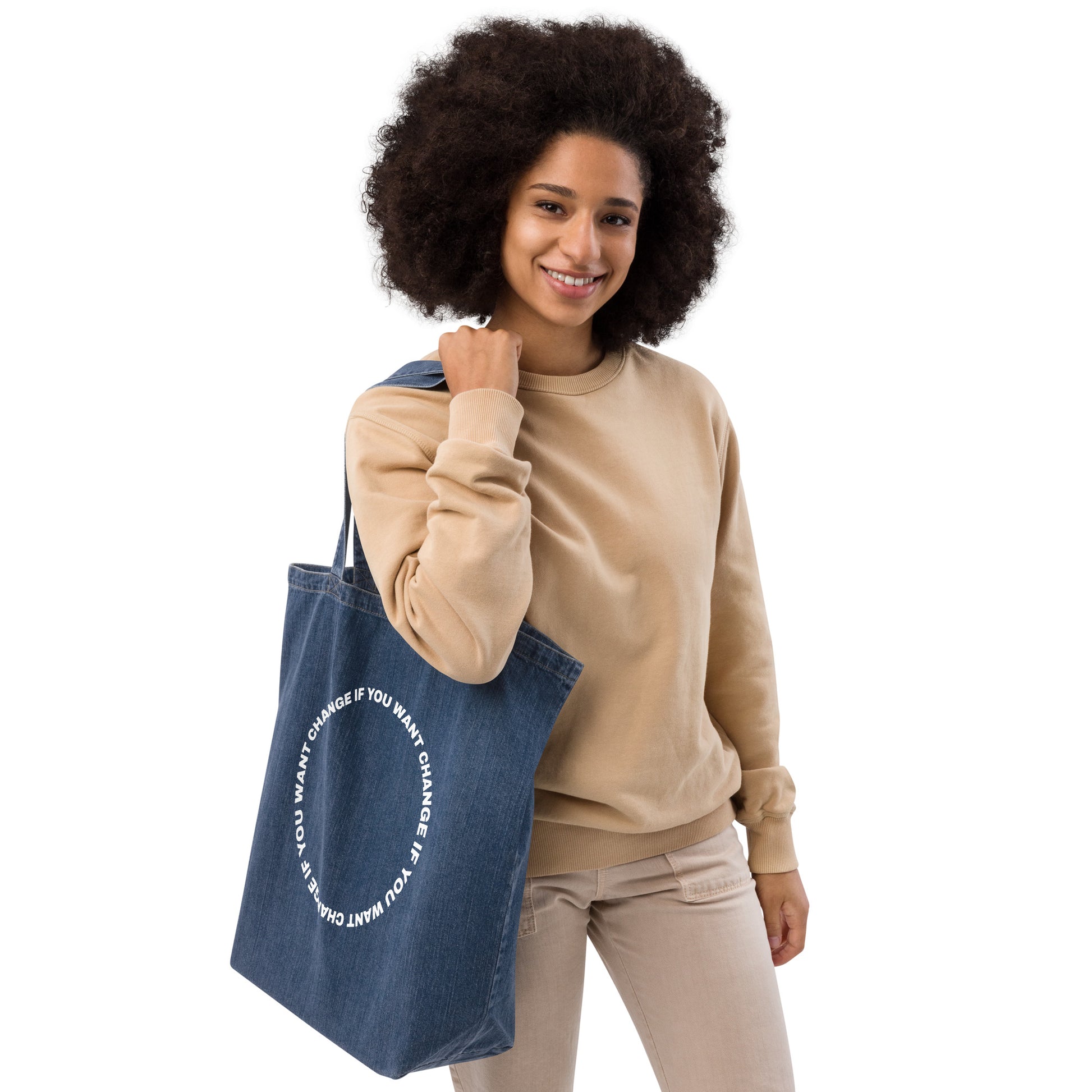 Organic denim tote bag with circular quote design, carried by the handles