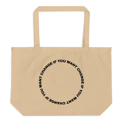 Black text in loop: "change if you want change" wrapped in a circle on an organic cotton tote bag