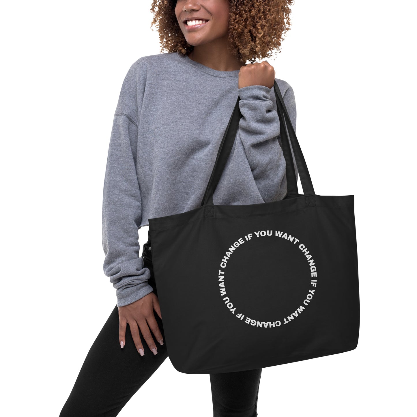 Organic cotton tote bag with white circular quote design, carried over the shoulder