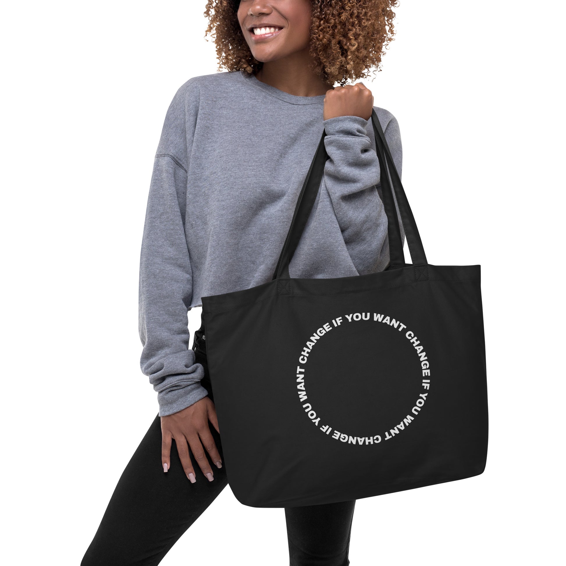 Organic cotton tote bag with white circular quote design, carried over the shoulder
