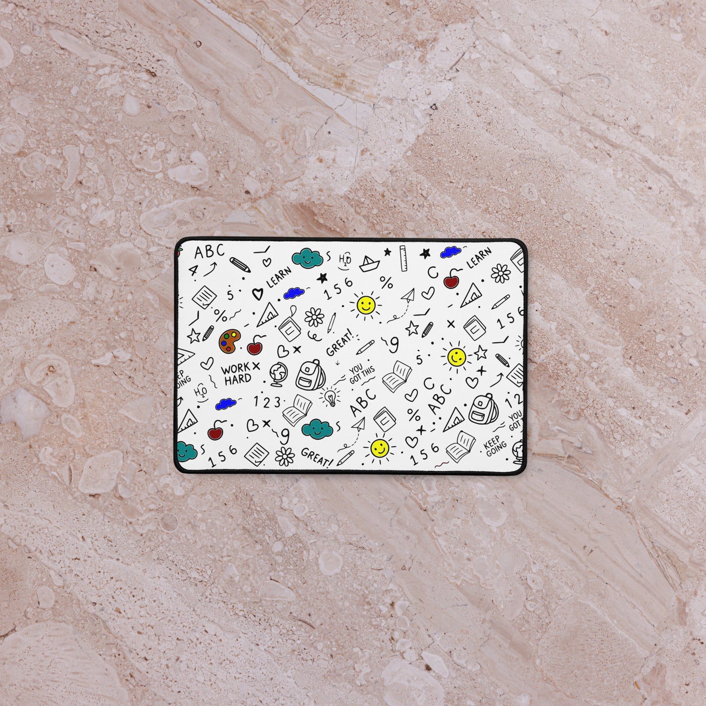 School doodle desk mat styled on a work-from-home setup — anti-slip rubber base, hemmed edges, flat lay view