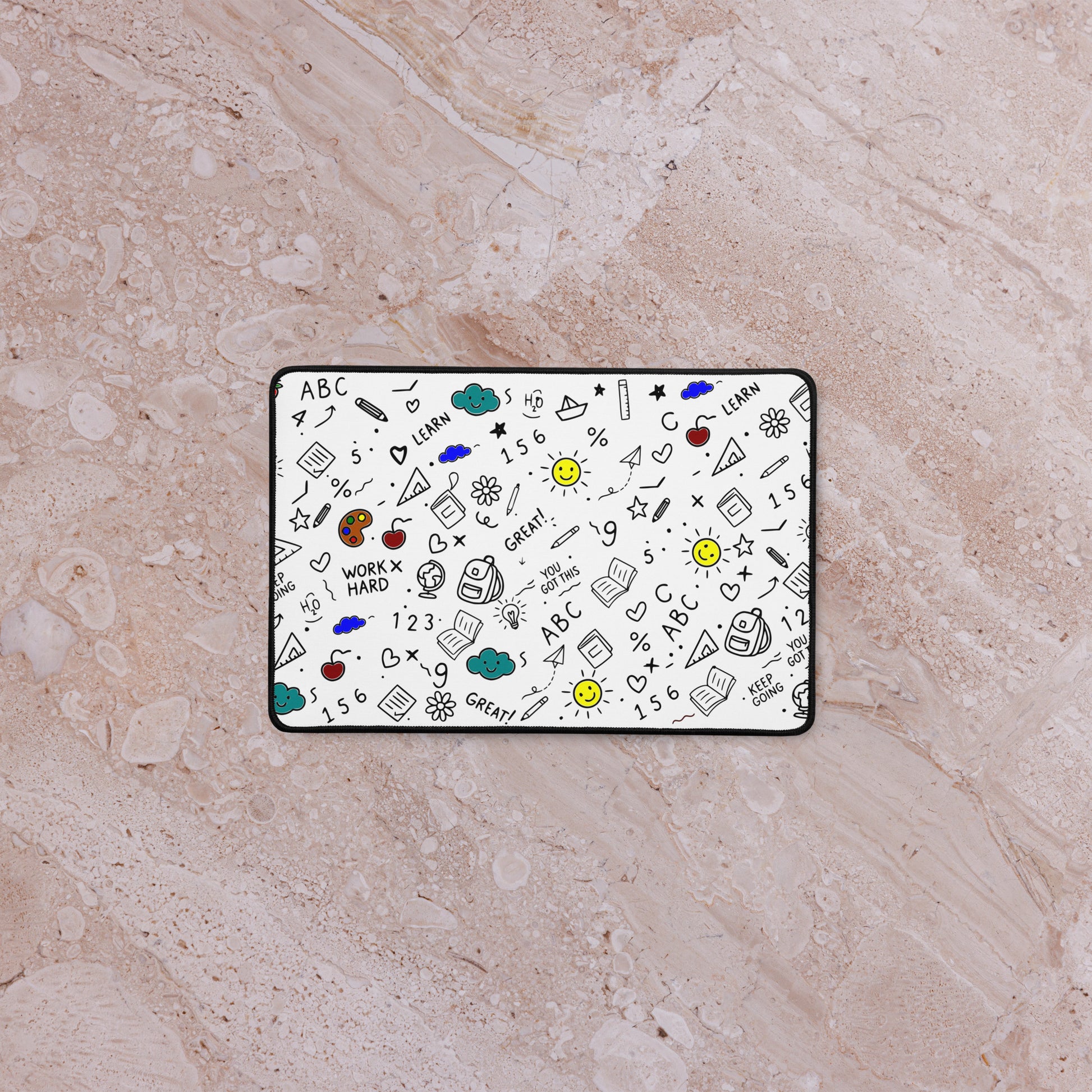  School doodle desk mat styled on a work-from-home setup — anti-slip rubber base, hemmed edges, flat lay view