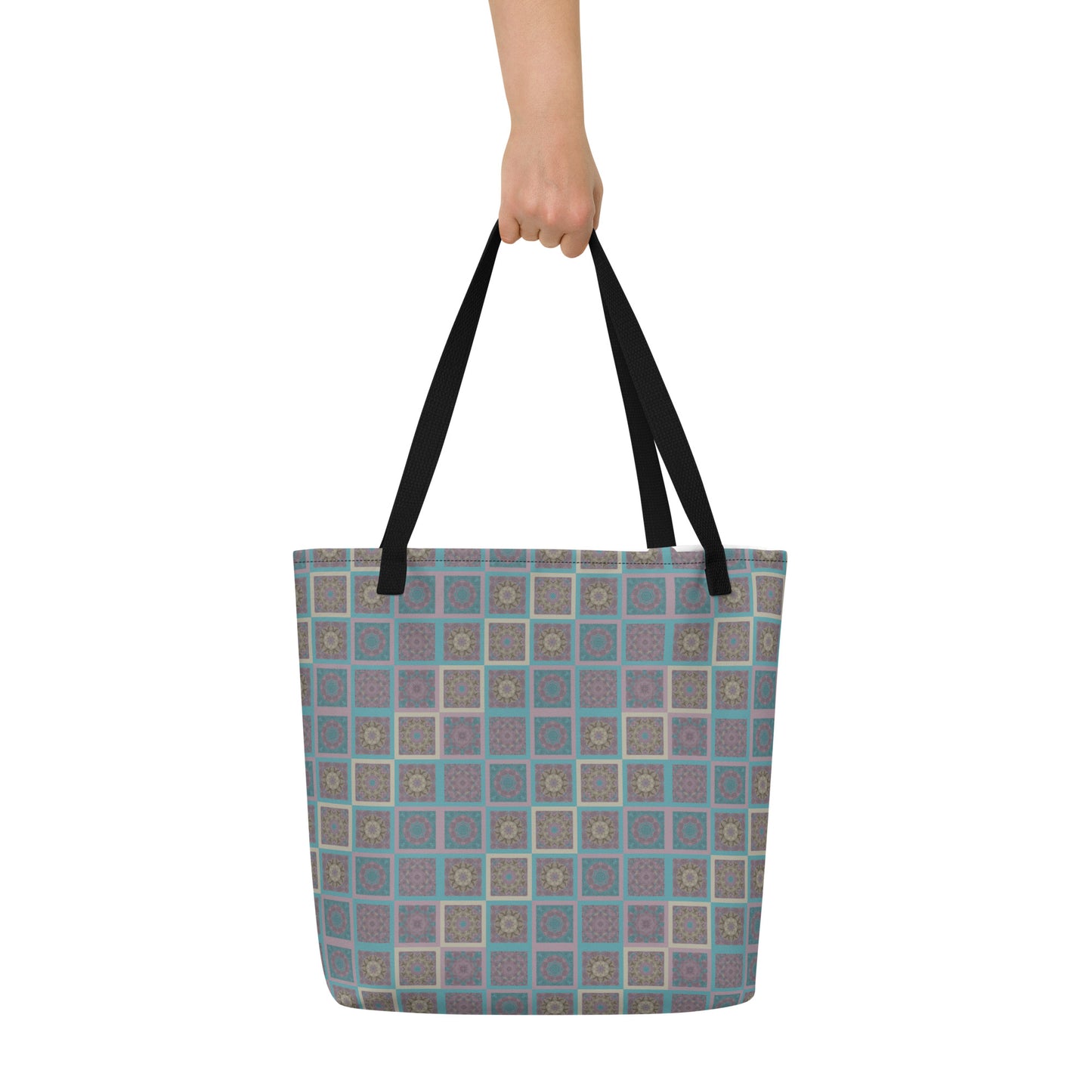 Mandala tiles tote bag held at shoulder — kaleidoscopic sacred geometry print in turquoise and mauve