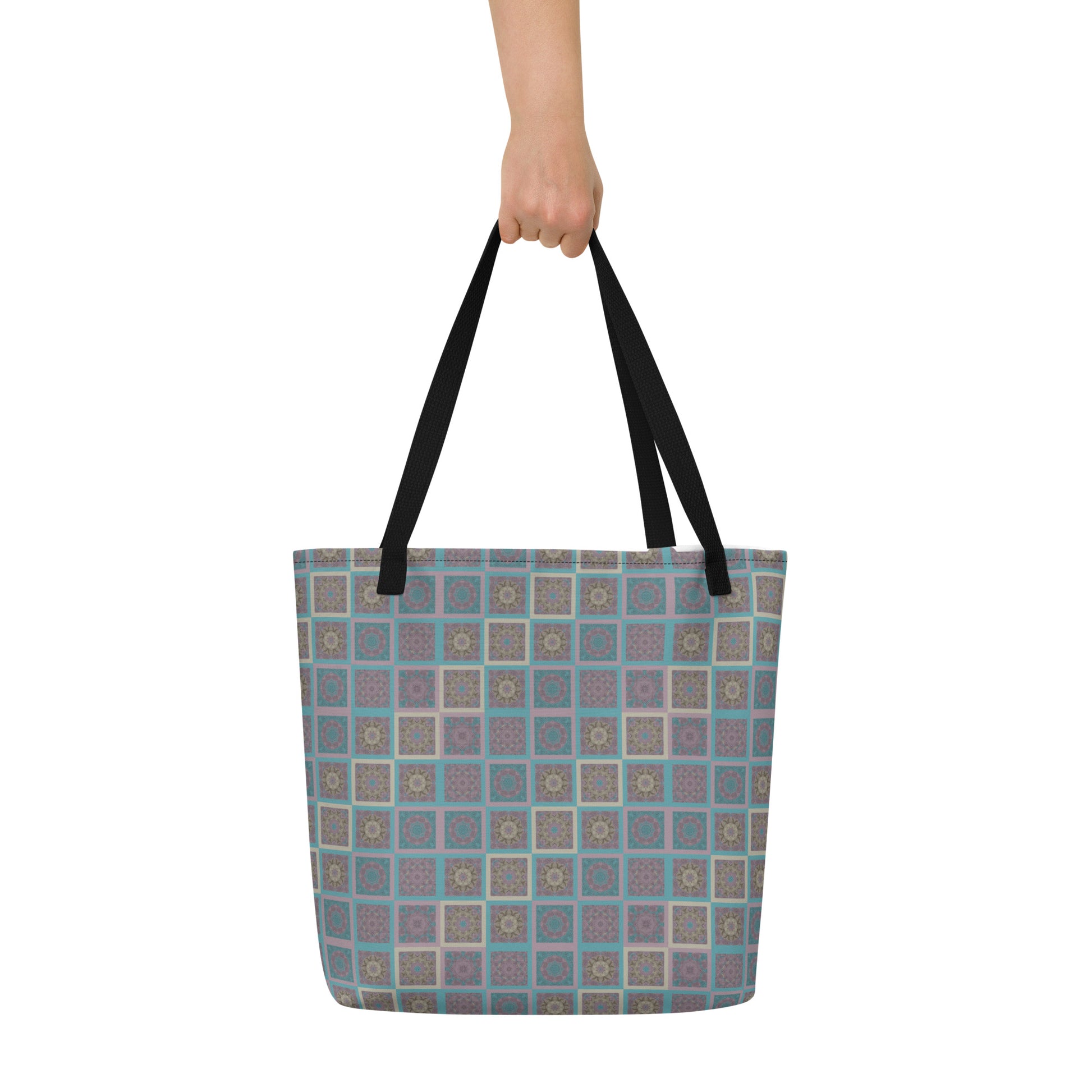 Mandala tiles tote bag held at shoulder — kaleidoscopic sacred geometry print in turquoise and mauve