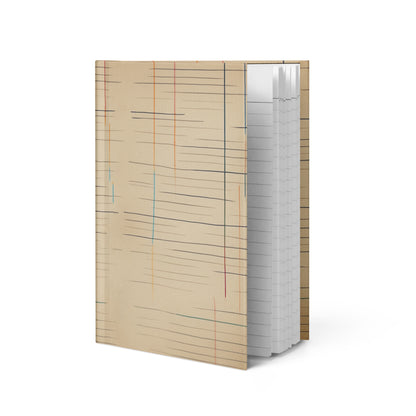Matte hardcover journal open at an angle, featuring a warm aged-paper design with faded horizontal lines and vertical color accents in red, blue, and orange — Old Lines, New Story by MWL.