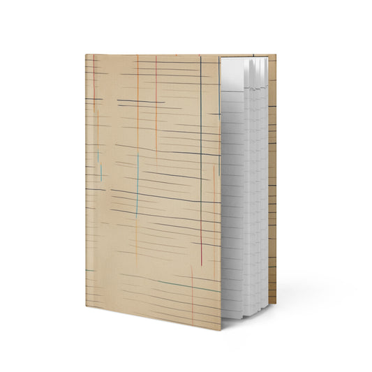 Matte hardcover journal open at an angle, featuring a warm aged-paper design with faded horizontal lines and vertical color accents in red, blue, and orange — Old Lines, New Story by MWL.