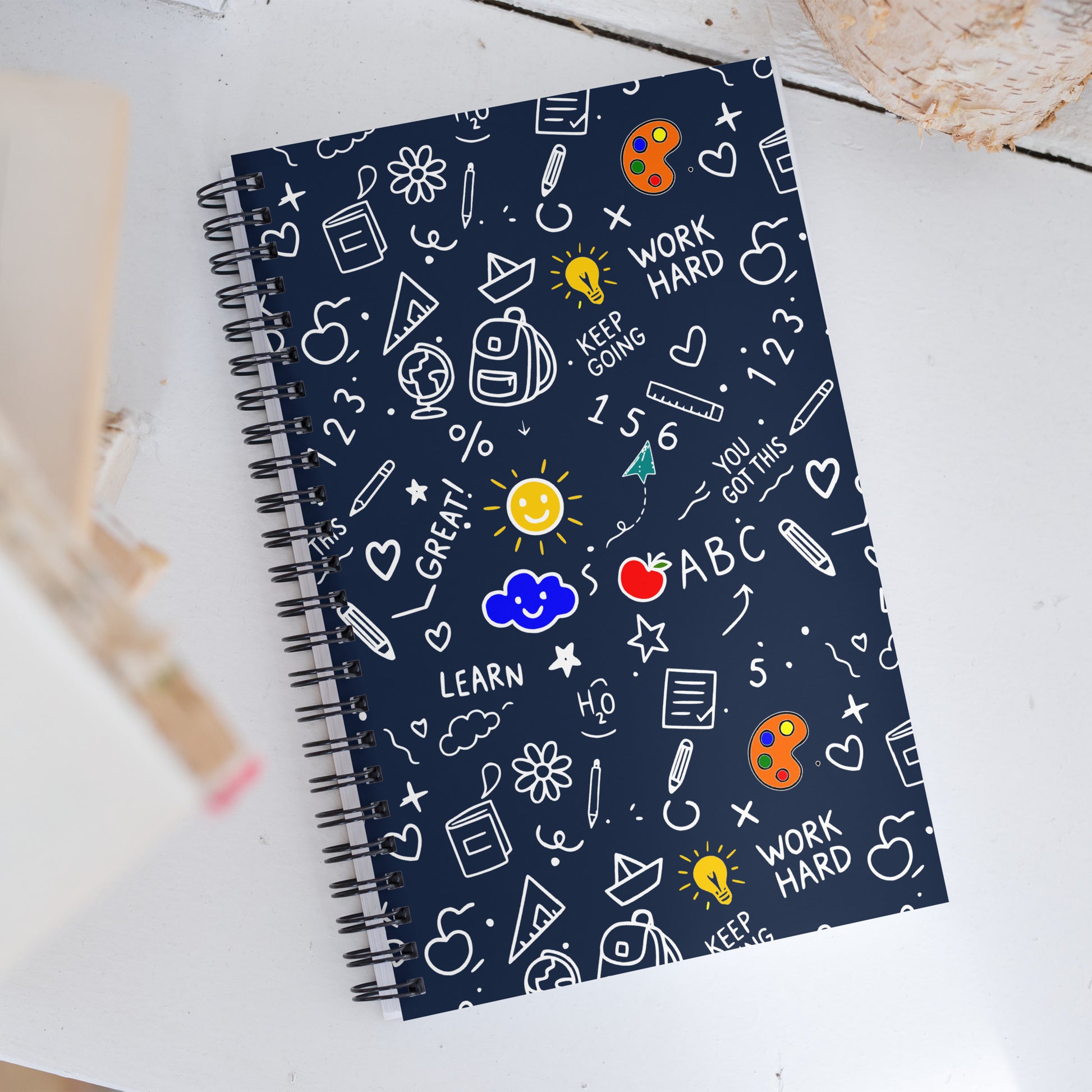 Wire-o spiral notebook with hand-drawn school doodle illustration on dark blue background — books, pencils, numbers and happy faces on soft-touch cover