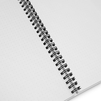 Open wire-o notebook showing dotted pages with cute school doodle cover design — flat-lay view