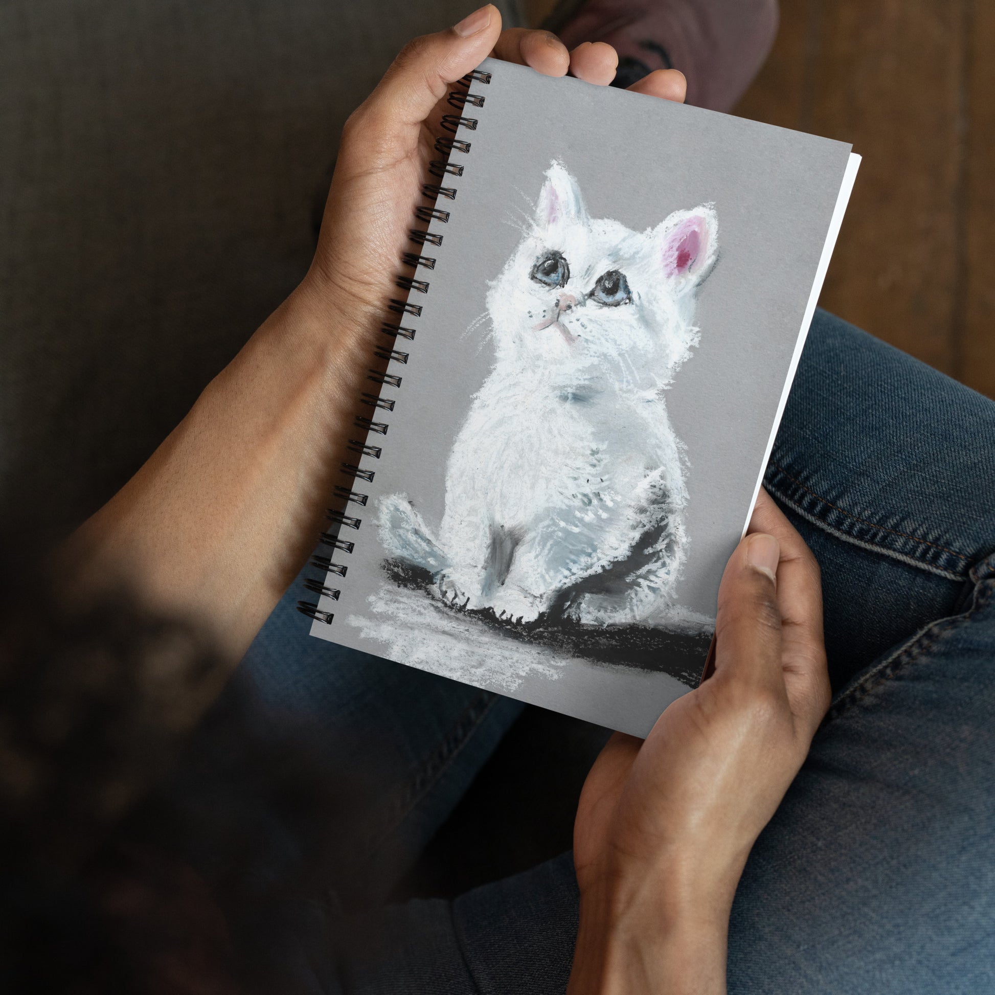 Wire-o spiral notebook with soft-touch cover featuring a soft pastel drawing of a white kitten with blue eyes, artwork by artist Lena Kloper