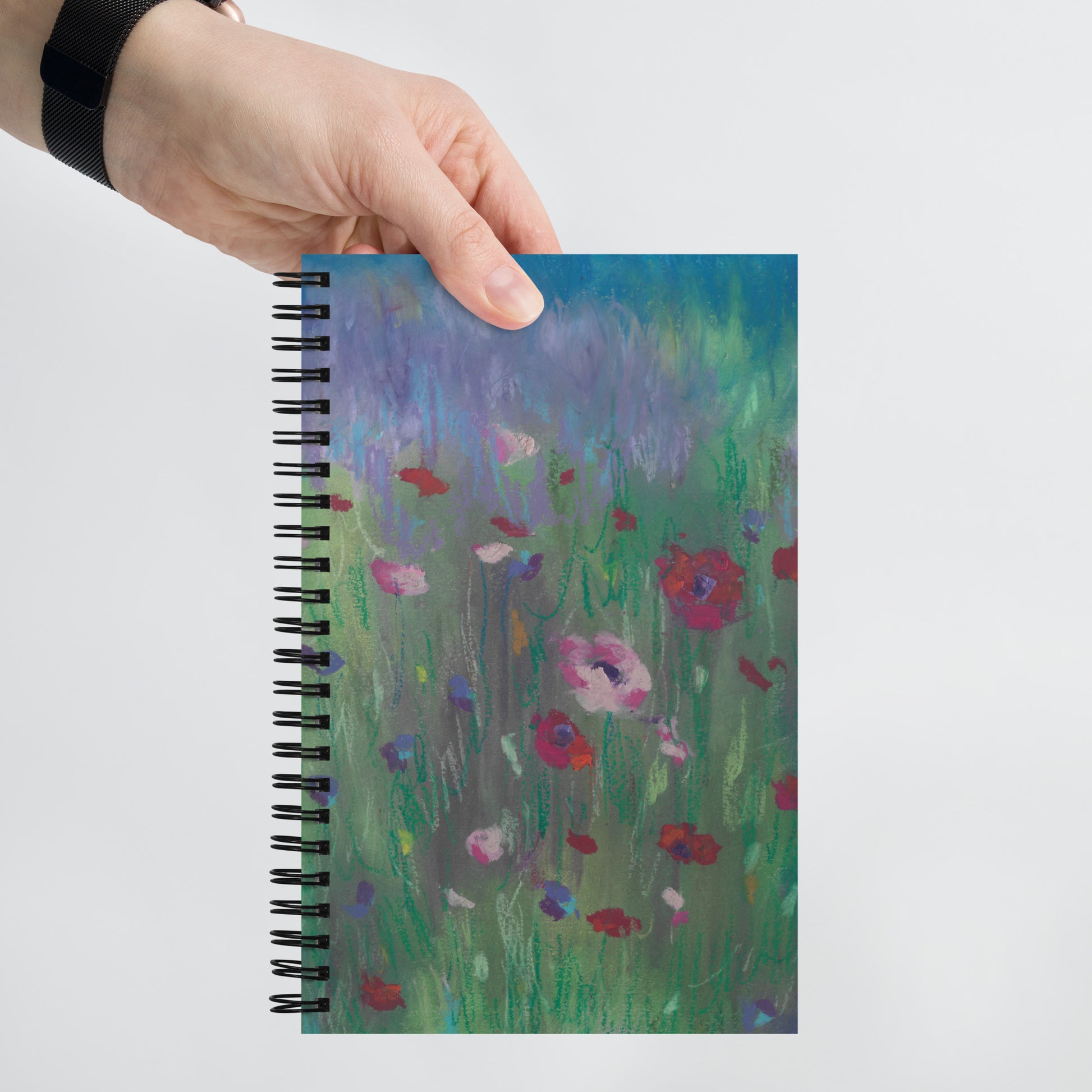 Flat lay of Wildflower Dreams dotted notebook with wire-o binding — pastel poppies and wildflowers cover, ideal for bullet journaling